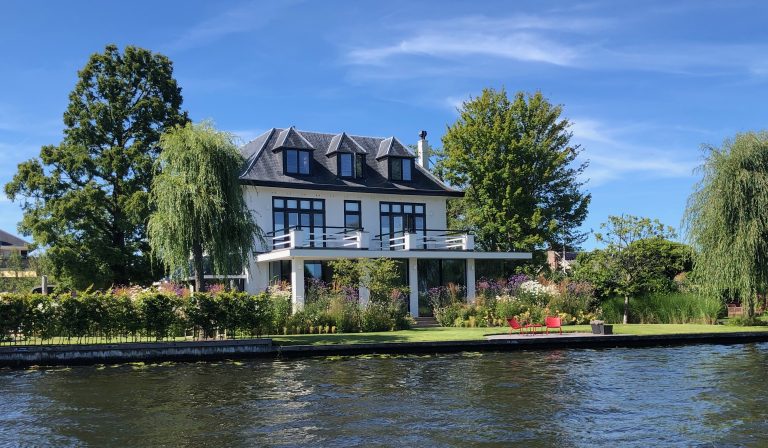 Luxe villa verbouwing aan het water – Villa aan de Leede met moderne aanbouw en zicht op de tuin