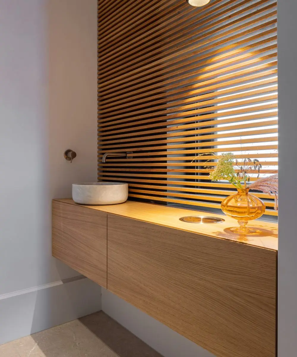 Design toiletmeubel met zwevende eiken kast, waskom en houten lattenwand – Villa aan de Leede