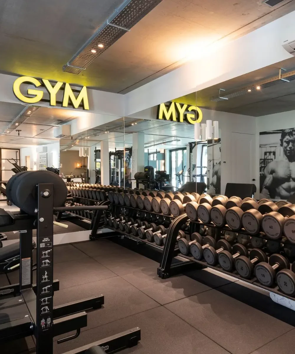 Gymruimte met gewichten en spiegels in villa Noordwijk