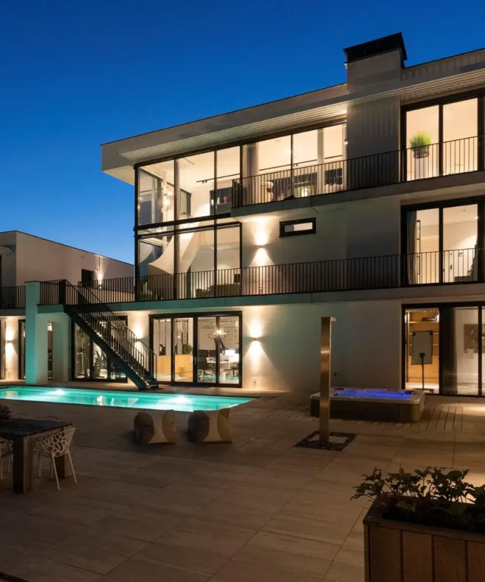 Sfeervolle avondopname van villa Noordwijk met pool, jacuzzi en buitenruimte