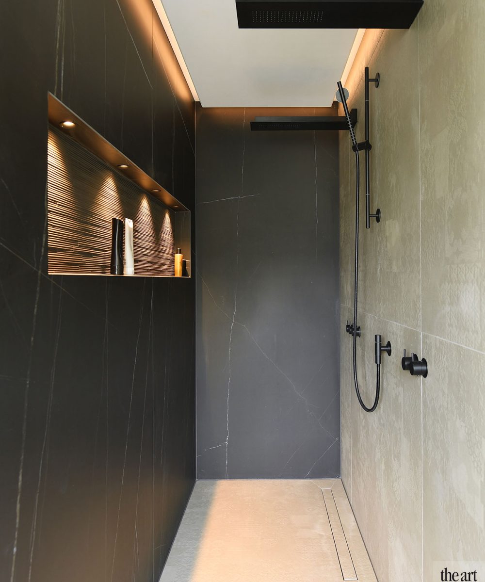 Inloopdouche met donkere wand en indirecte verlichting