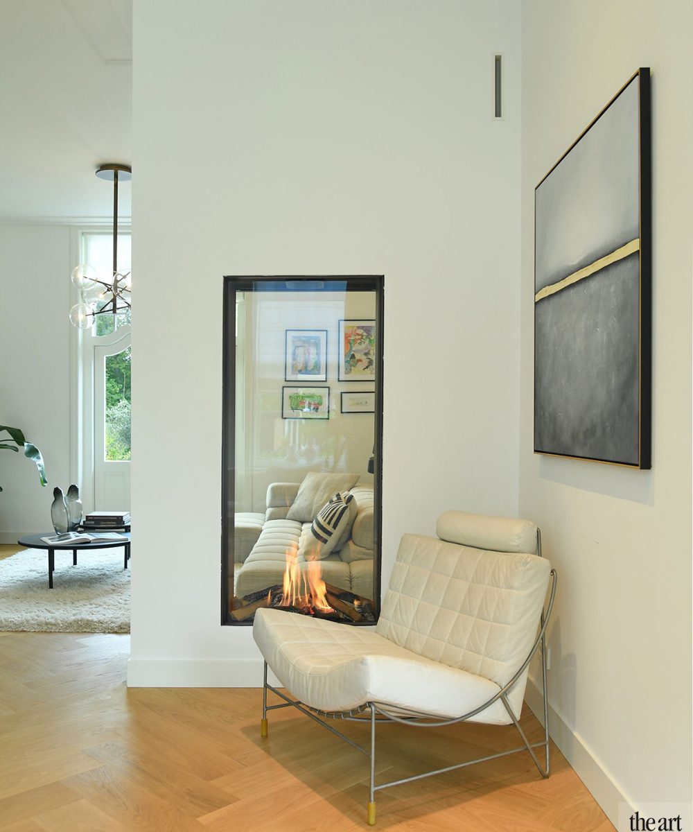 Woonkamer met haard en fauteuil op een visgraatvloer