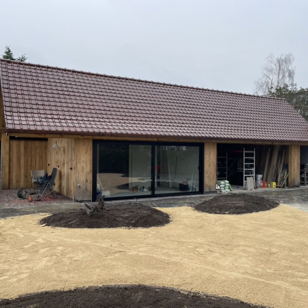 Het bijgebouw van hout en glas is gereed, de tuin van Huize INA wordt aangelegd