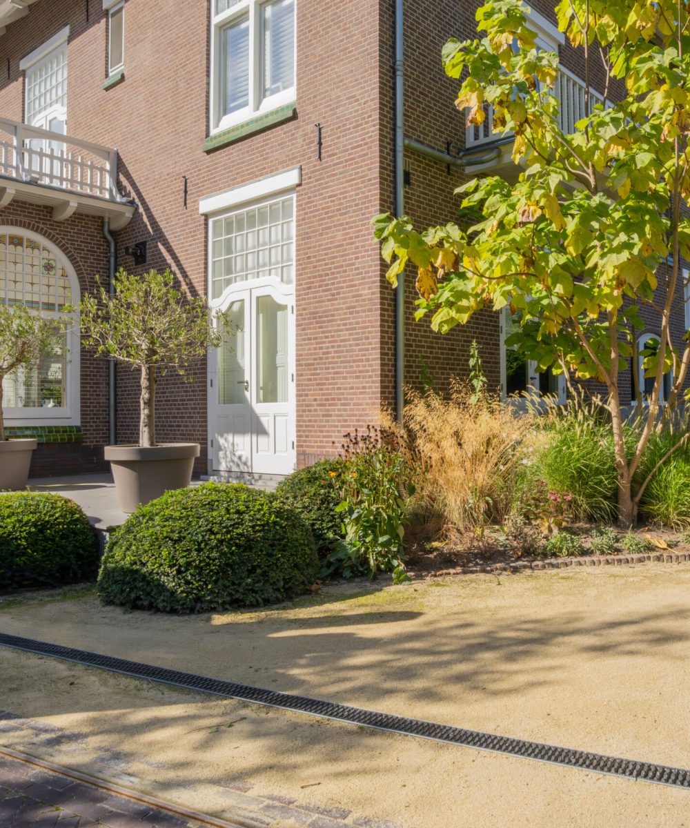 De serre van Huize INA met de nieuwe beplanting en halfverharding ervoor, tuinontwerp KamerlingvanderBurgh