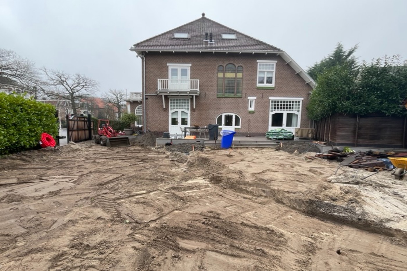 De tuin achter het landhuis als kale zandvlakte tijdens de verbouwing