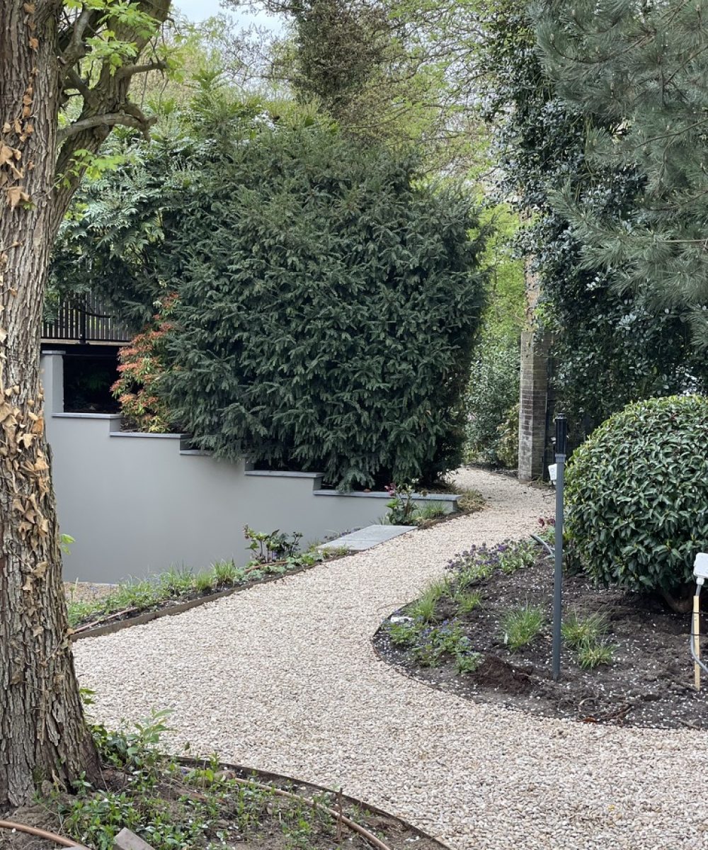 Grindpad dat langs de zijkant van de tuin van Villa Boechorst in Noordwijk naar achteren loopt. Tuinontwerp KamerlingvanderBurgh.