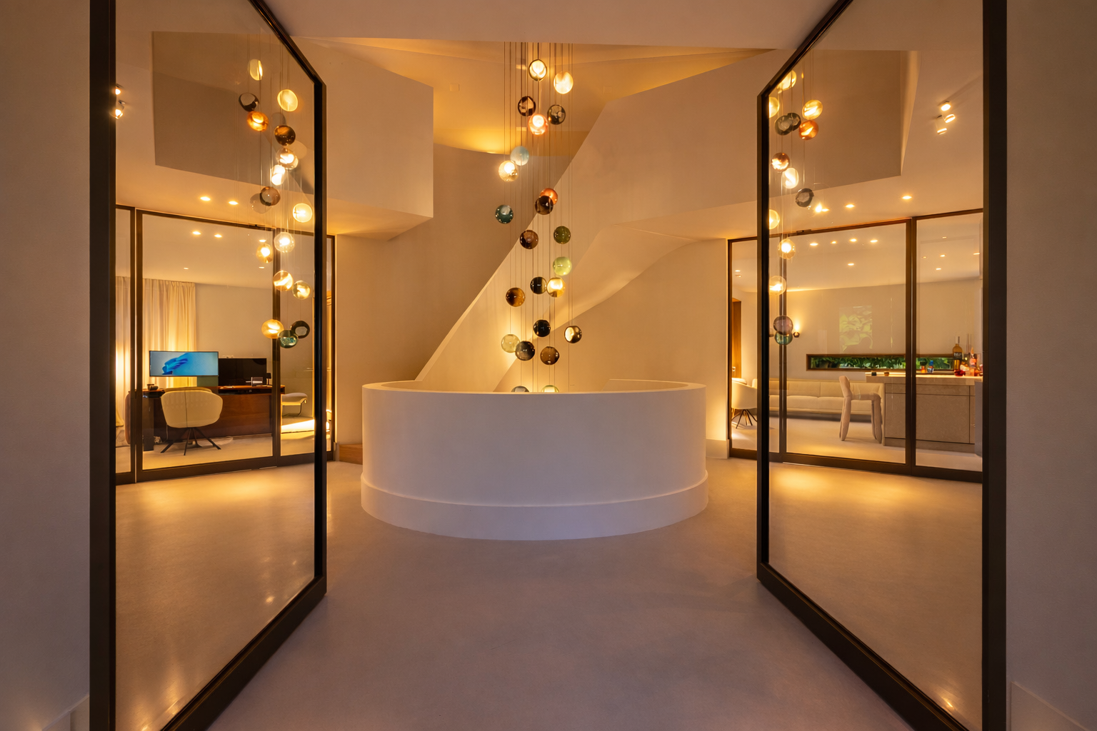 Hal van Villa Boechorst in Noordwijk na de verbouwing, met de sculpturale trap, de ronde zitbank en alle verlichting aan