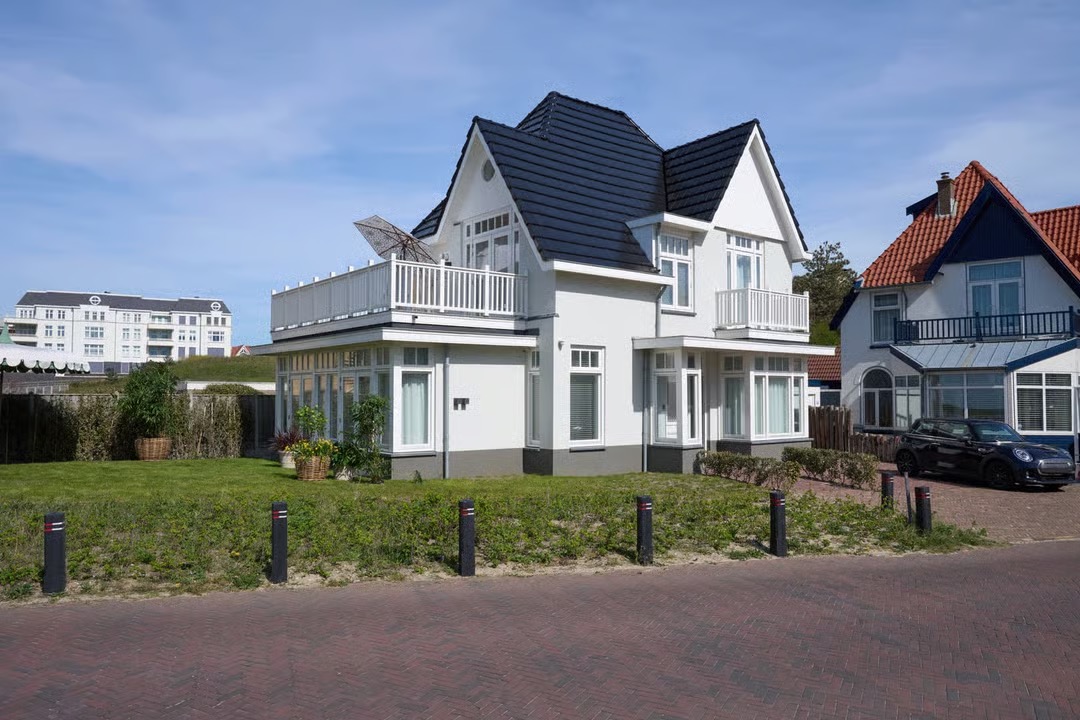 Villa Zeezicht in Noordwijk: wit gestucte villa met donker pannendak en balkons, na de verbouwing door KamerlingvanderBurgh