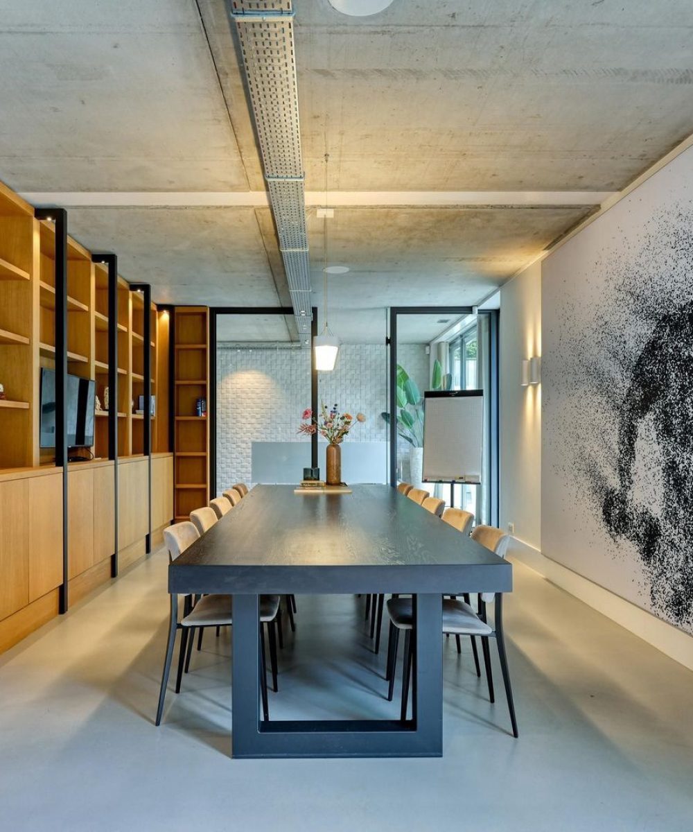 Eetkamer met houten boekenwand en kunstwerk in Villa Zuidduinen in Noordwijk. Ontwerp KamerlingvanderBurgh.