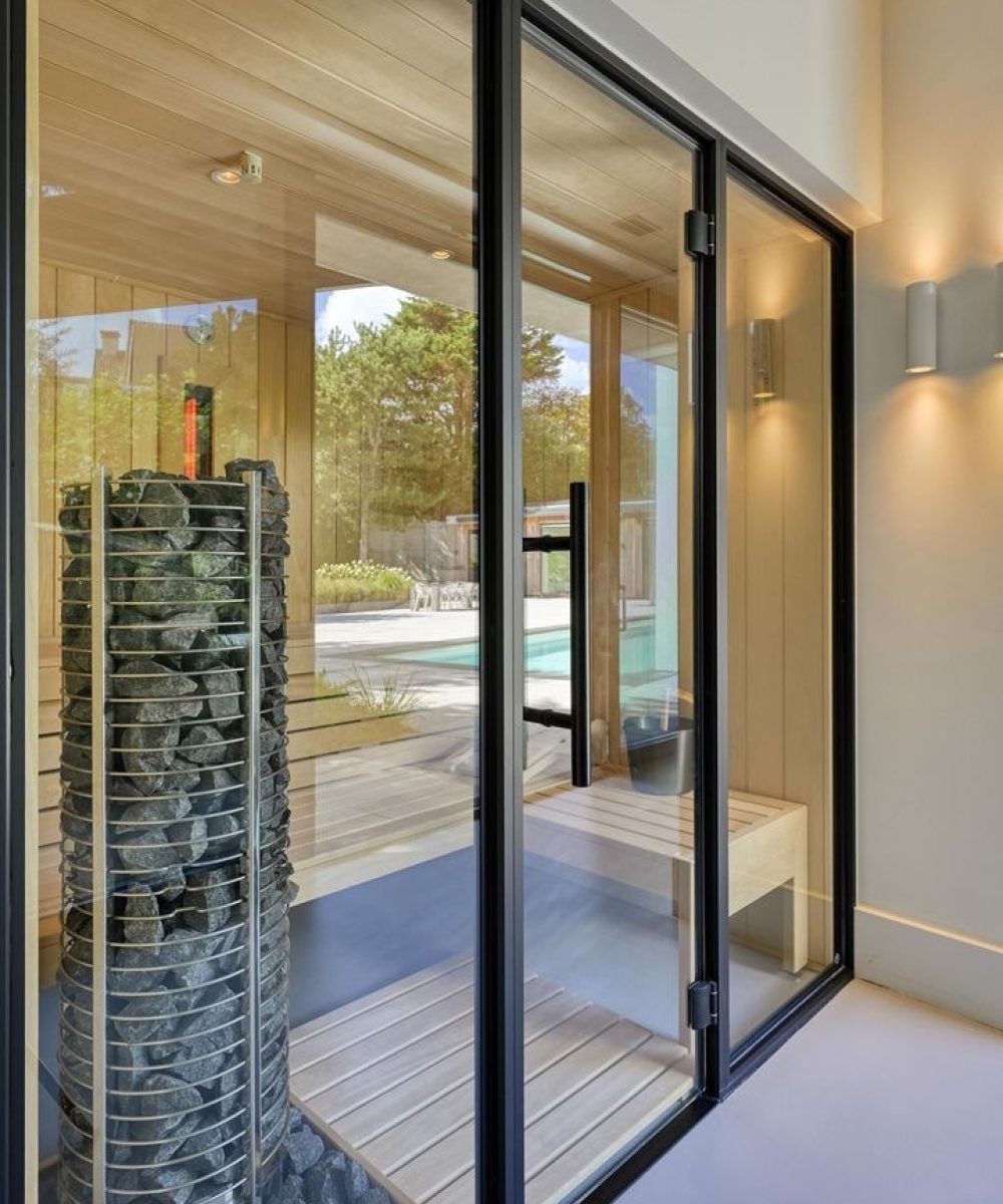 Sauna achter een glazen pui in Villa Zuidduinen in Noordwijk. Ontwerp KamerlingvanderBurgh.