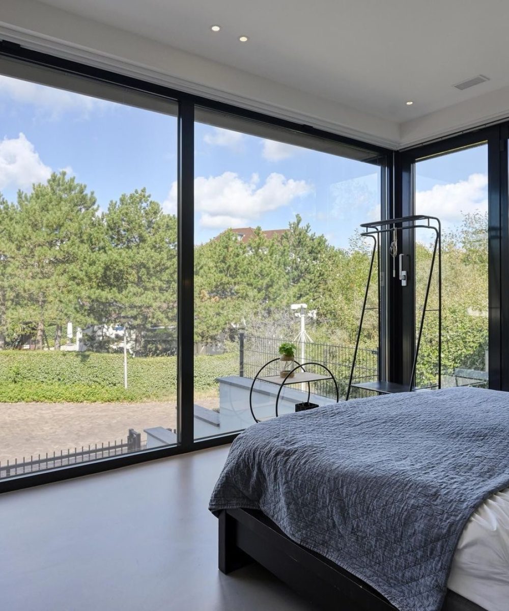 Slaapkamer met glazen hoek en uitzicht op het groen in Villa Zuidduinen in Noordwijk. Ontwerp KamerlingvanderBurgh.
