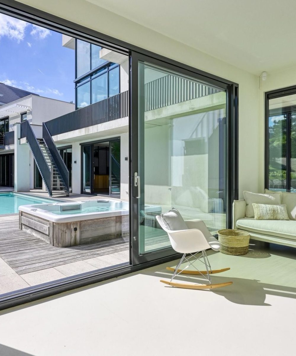 Zitkamer met schuifpui naar het zwembad in Villa Zuidduinen in Noordwijk. Ontwerp KamerlingvanderBurgh.